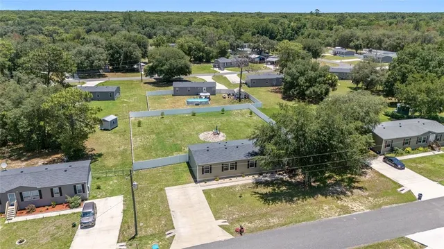 an aerial view of a house with a garden and lake view
