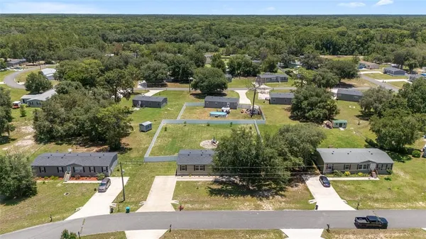 an aerial view of residential houses with outdoor space and street view