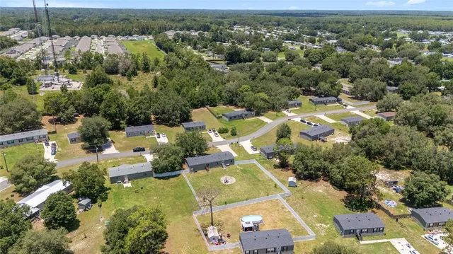 an aerial view of residential houses with outdoor space and trees