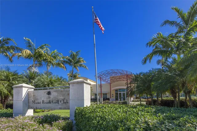a front view of a house with plants and palm trees