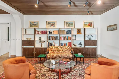 a living room with furniture and a book shelf
