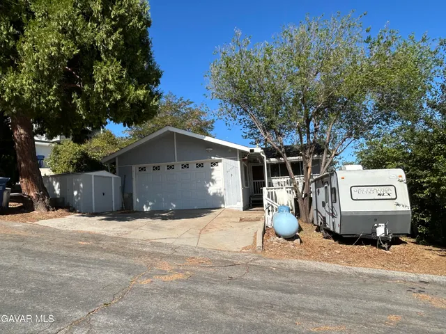 a view of a house with a yard and tree