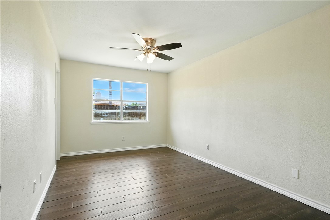 833 Orleans Drive Corpus Christi, TX 78418 - Photo 13 of 18 a view of an empty room with wooden floor and a window