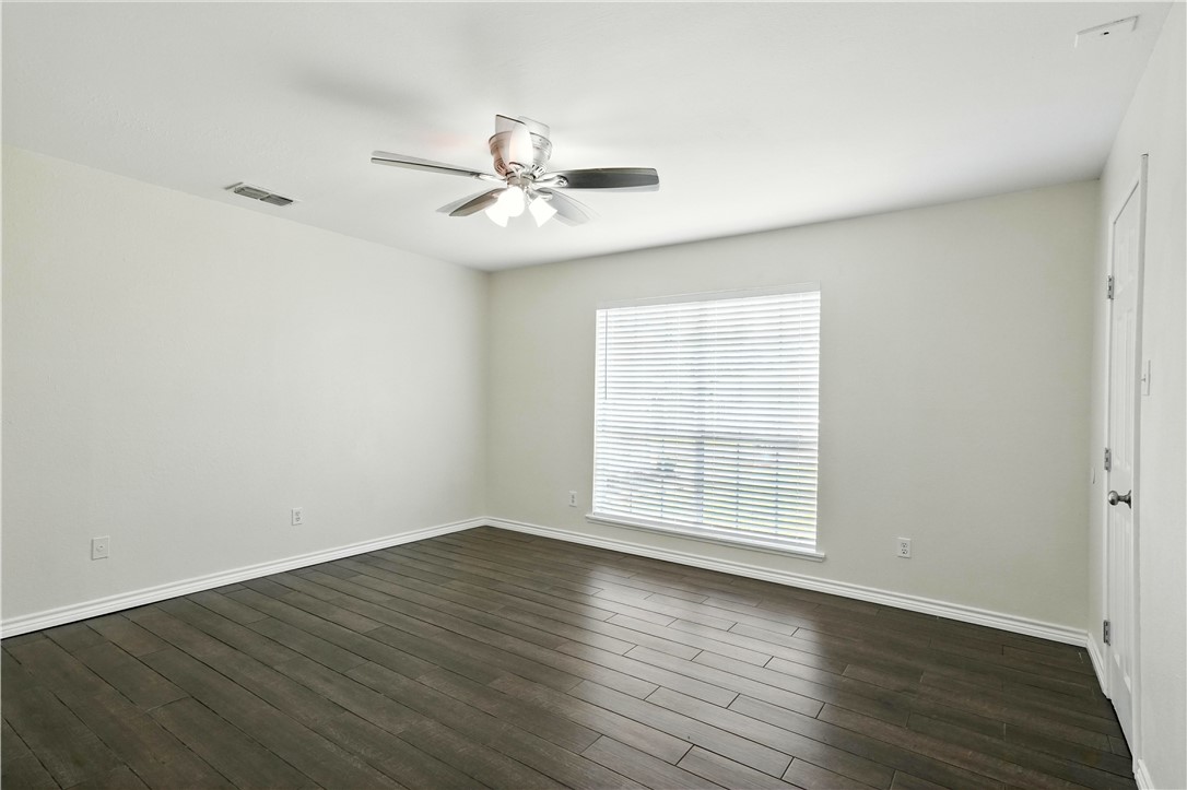 833 Orleans Drive Corpus Christi, TX 78418 - Photo 8 of 18 an empty room with wooden floor fan and windows