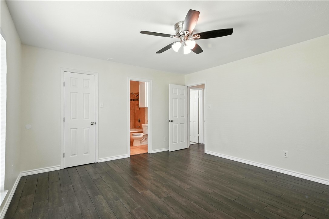 833 Orleans Drive Corpus Christi, TX 78418 - Photo 10 of 18 an empty room with wooden floor fan and windows