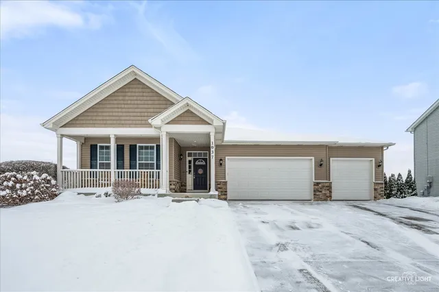 a kitchen with stainless steel appliances granite countertop a stove a refrigerator a kitchen island a table and chairs with wooden floor