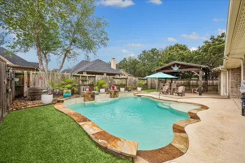 a view of a swimming pool with lounge chairs in patio