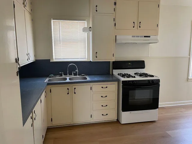 a kitchen with granite countertop white cabinets and black appliances