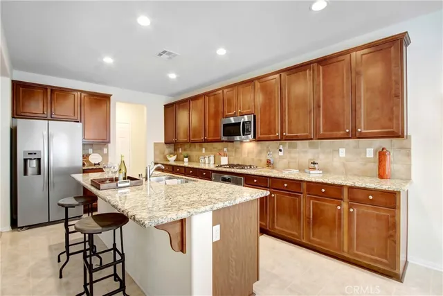 a kitchen with stainless steel appliances granite countertop a sink refrigerator and cabinets