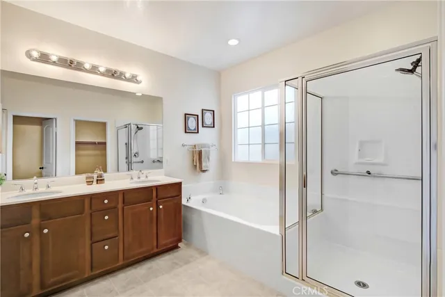a spacious bathroom with a tub sink shower and mirror