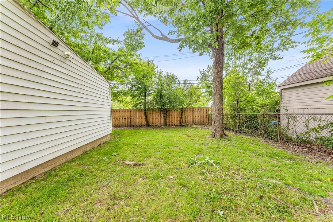 18517 Homeway Road Cleveland, OH 44135 - Photo 26 of 29 Expansive exterior space featuring a manicured lawn, established tree, wood privacy fencing, and chain-link fencing