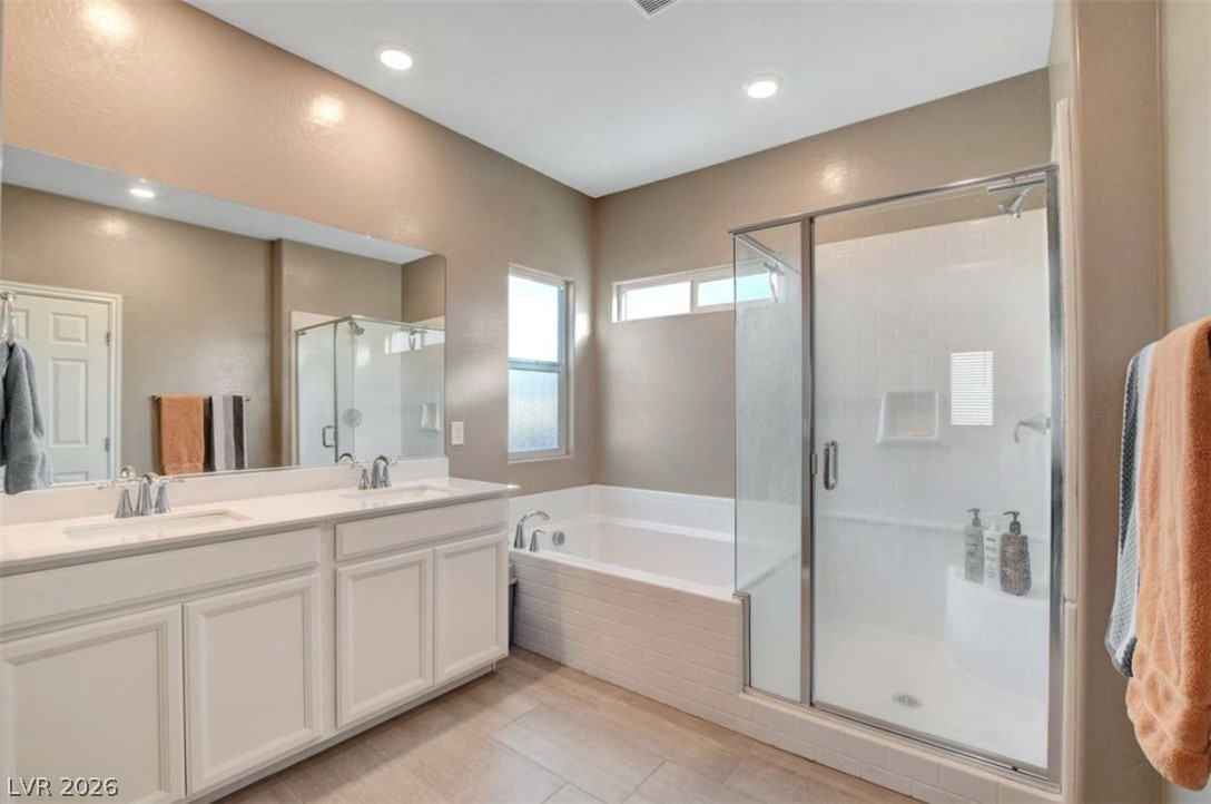 6920 Fossil Rim Street North Las Vegas, NV 89084 - Photo 6 of 9 Dual vanity sinks and a separate shower and soaking tub create a luxurious bathing experience.