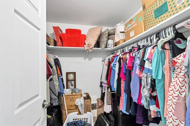 a view of walk in closet with clothes and shoes