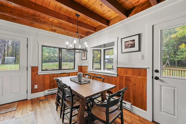 a kitchen with stainless steel appliances kitchen island granite countertop a table chairs in it and wooden floors