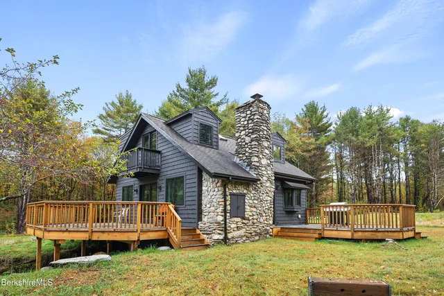 a front view of a house with a garden and trees