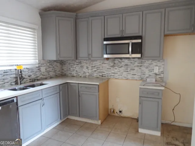 a kitchen with stainless steel appliances granite countertop a sink and a microwave