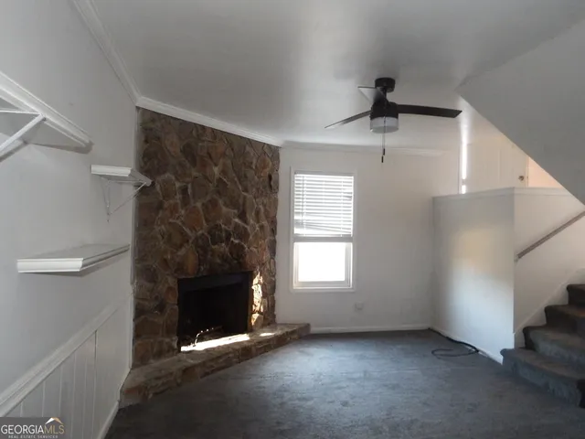 a view of an empty room with a fireplace and a window