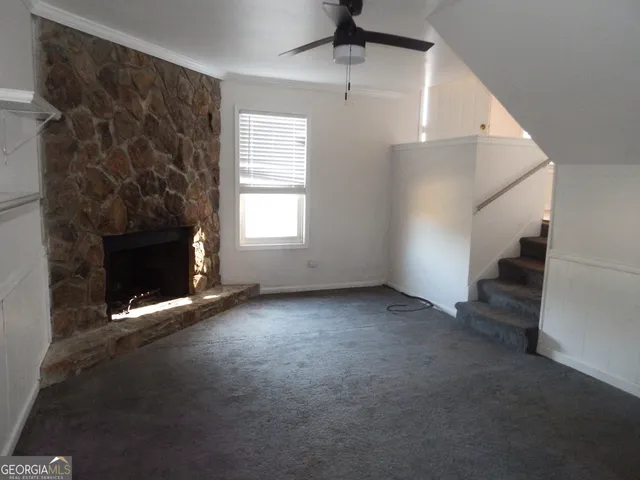 an empty room with windows and fireplace