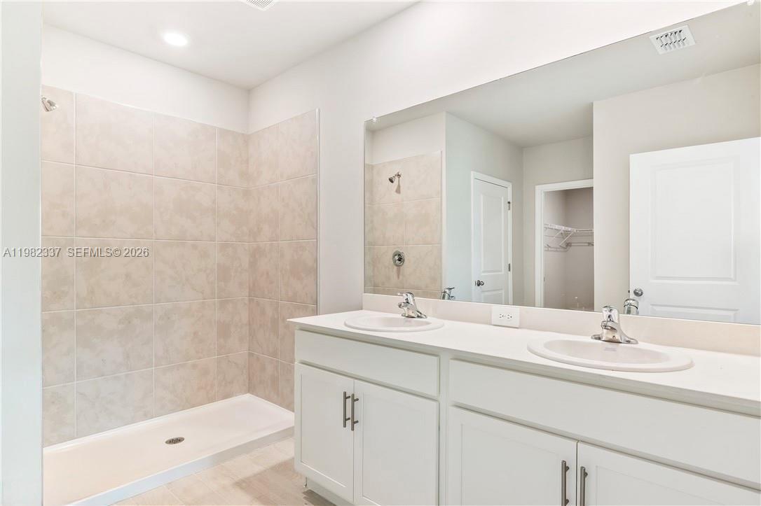 5215 Butte Street Lehigh Acres, FL 33971 - Photo 10 of 15 a bathroom with a sink double vanity granite tub shower and a mirror