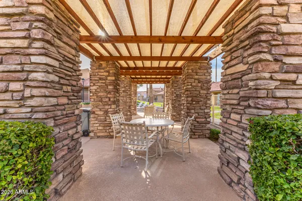 a patio with table and chairs and potted plants