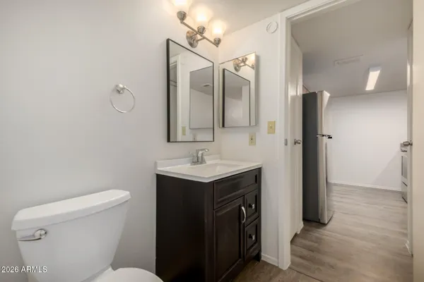 a bathroom with a sink a toilet a mirror and shower