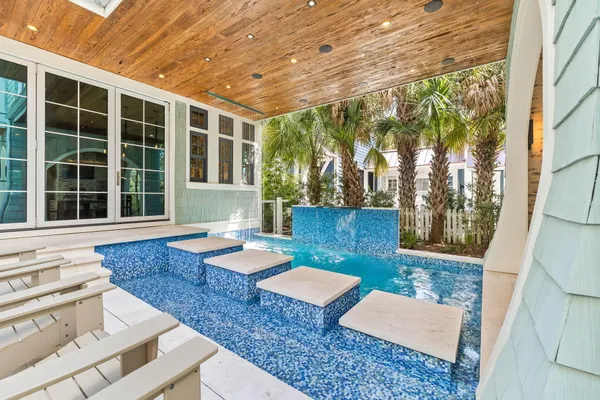 a balcony with wooden floor table and chairs