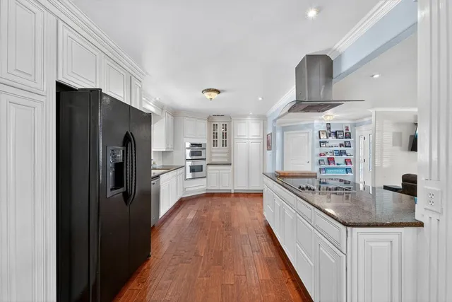 a kitchen with stainless steel appliances granite countertop a refrigerator a stove and a sink