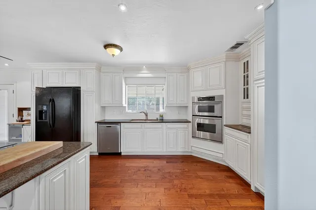 a kitchen with granite countertop a refrigerator and a stove top oven