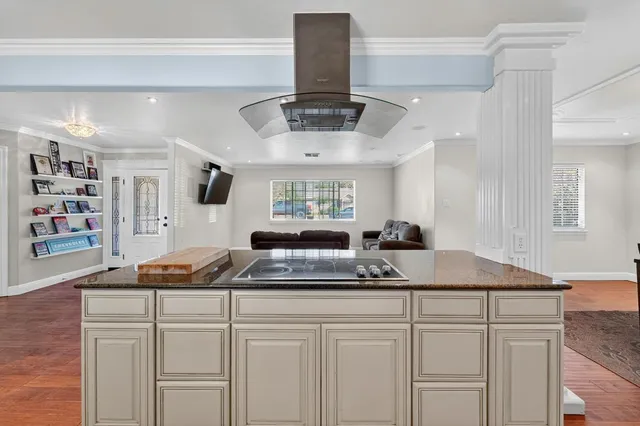 a kitchen with a sink dishwasher and white cabinets with wooden floor