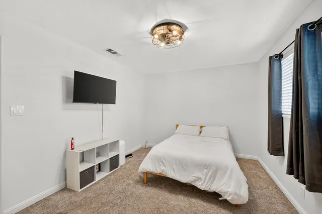 a bedroom with a bed and a flat screen tv