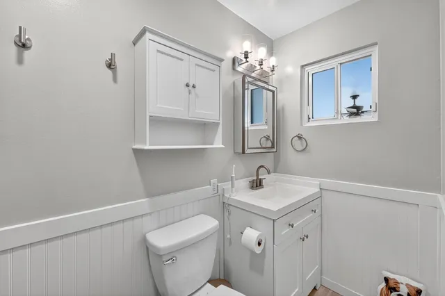 a bathroom with a sink a toilet and mirror