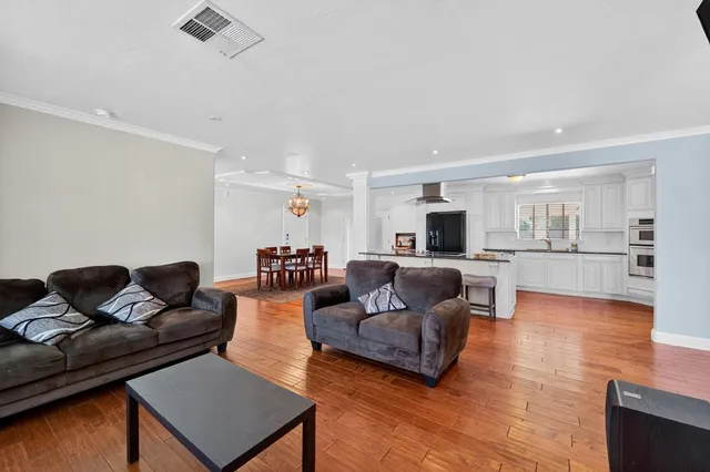 a living room with furniture and a wooden floor