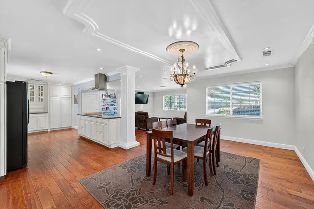 a view of a dining room with furniture a chandelier and wooden floor
