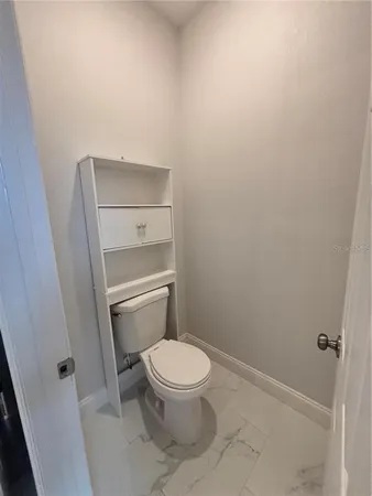 a white toilet sitting next to a shower