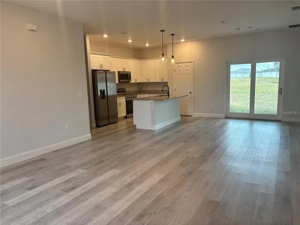 a view of kitchen with wooden floor and electronic appliances