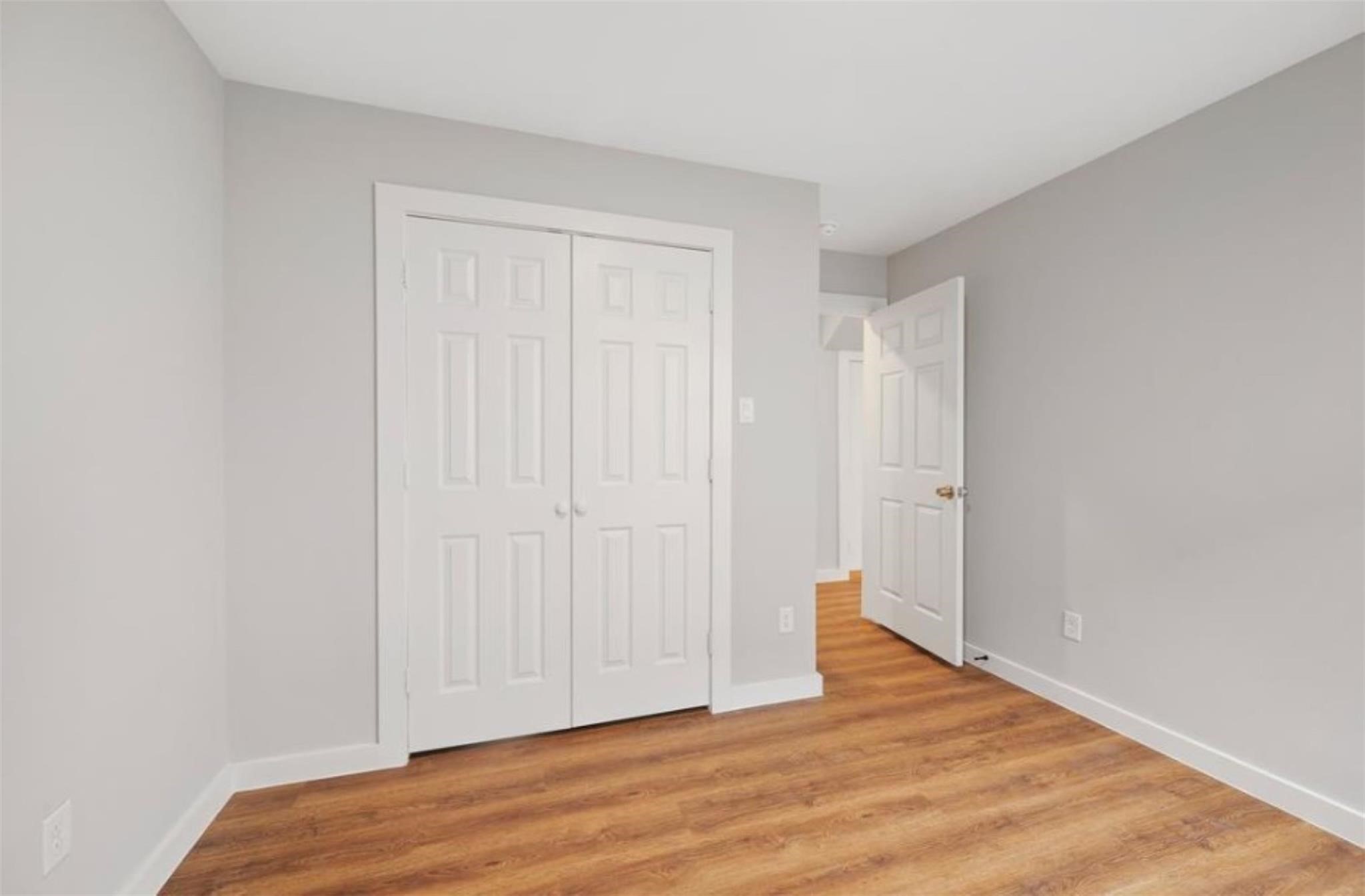 8120 Laura Koppe Road, Unit B Houston, TX 77028 - Photo 13 of 25 This room features neutral gray walls, warm wood flooring, and a white double closet. It's bright and spacious, ideal for a bedroom or home office.
