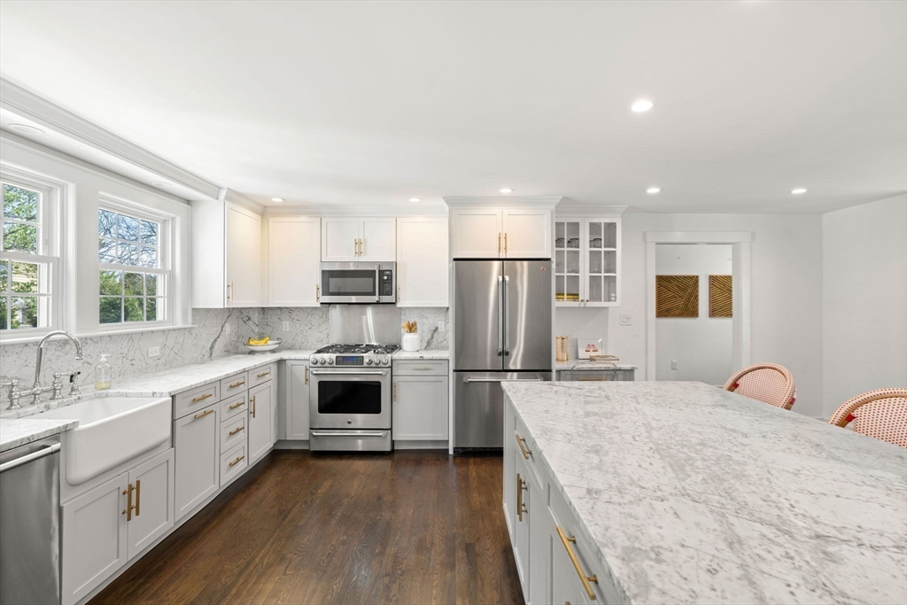 28 Rose Avenue Marblehead, MA 01945 - Photo 4 of 31 a large kitchen with stainless steel appliances granite countertop a stove a sink dishwasher a refrigerator and white cabinets with wooden floor