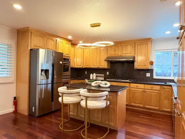 a kitchen with a refrigerator and a stove top oven
