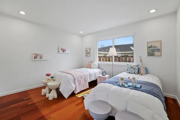a bedroom with two beds and a window