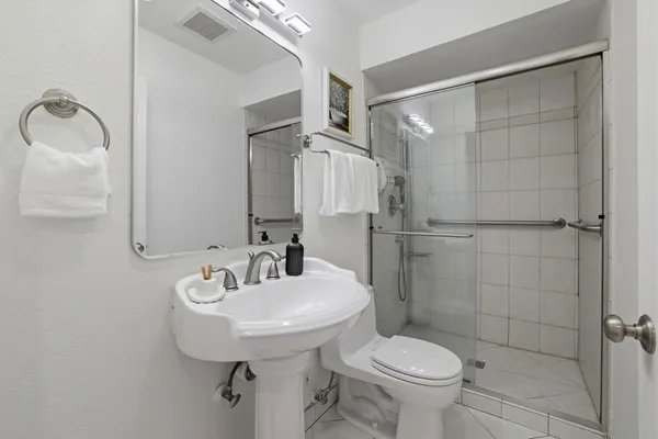 a bathroom with a sink toilet and shower