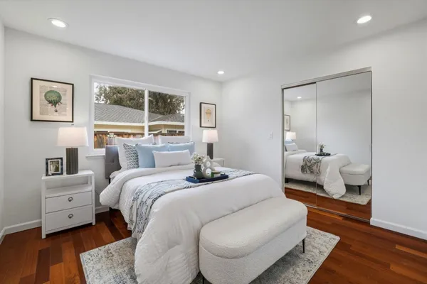 a bedroom with a bed and wooden floor