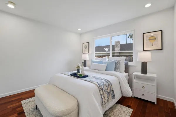 a bedroom with a bed and wooden floor