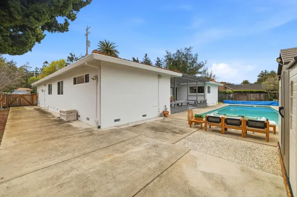 a backyard of a house with table and chairs