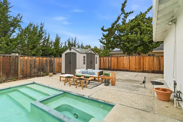 a backyard of a house with table and chairs