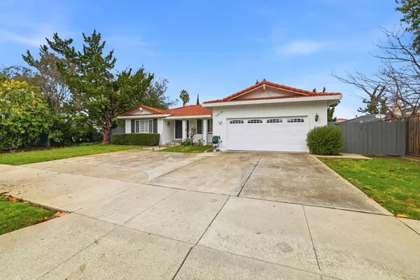 a front view of a house with a yard and potted plants