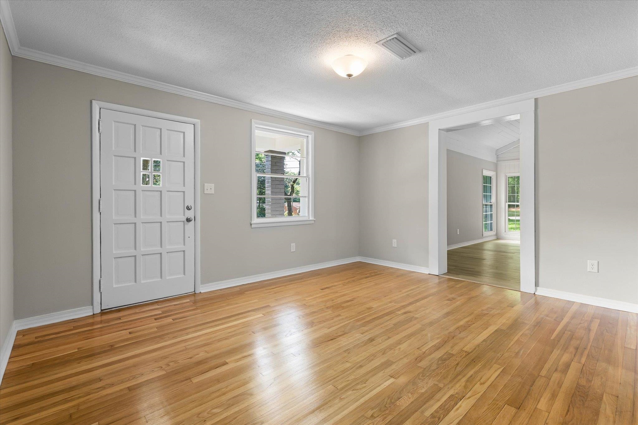 4700 Bit And Spur Road Mobile, AL 36608 - Photo 3 of 21 Entryway with light wood-style floors, plenty of natural light, visible vents, and ornamental molding