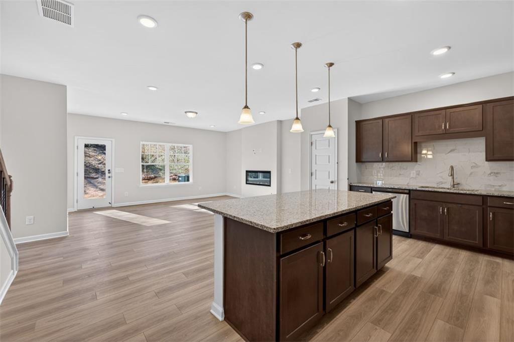 224 Bastian Drive, Unit 116 Villa Rica, GA 30180 - Photo 11 of 33 a kitchen with a stove a sink a window and wooden floor
