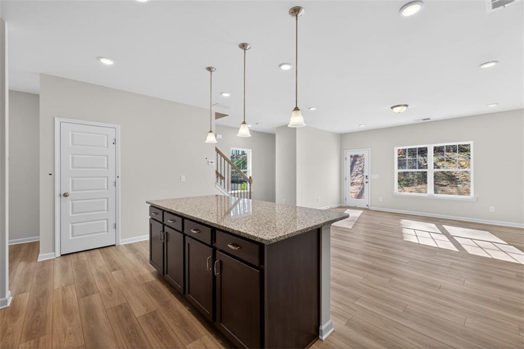 224 Bastian Drive, Unit 116 Villa Rica, GA 30180 - Photo 13 of 33 a kitchen with stainless steel appliances granite countertop a kitchen island a stove and a wooden floors