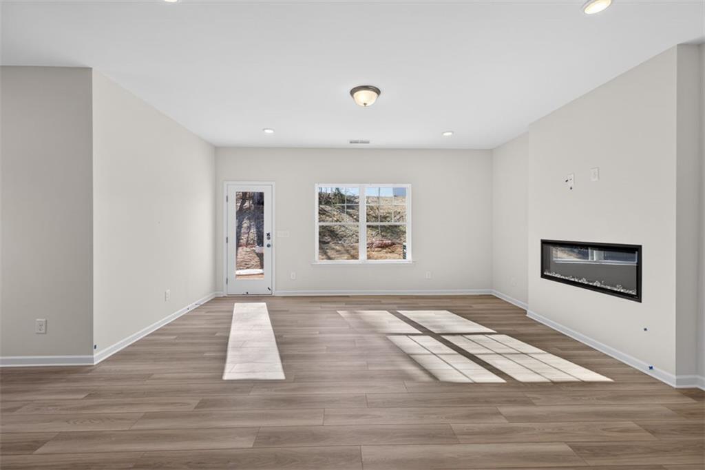 224 Bastian Drive, Unit 116 Villa Rica, GA 30180 - Photo 9 of 33 a view of an empty room with a window and wooden floor