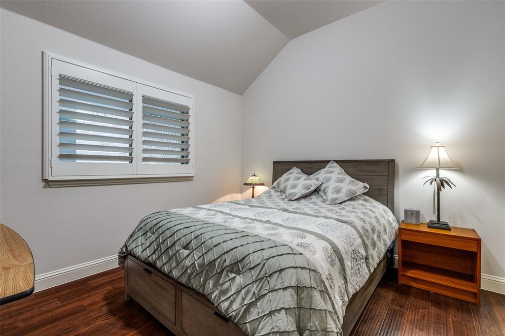 4217 Switchgrass Street Celina, TX 75009 - Photo 19 of 25 a bedroom with a bed and wooden floor